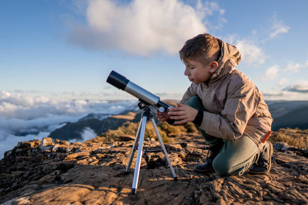 istock Young explorer high in the mountains with telescope 1415709397