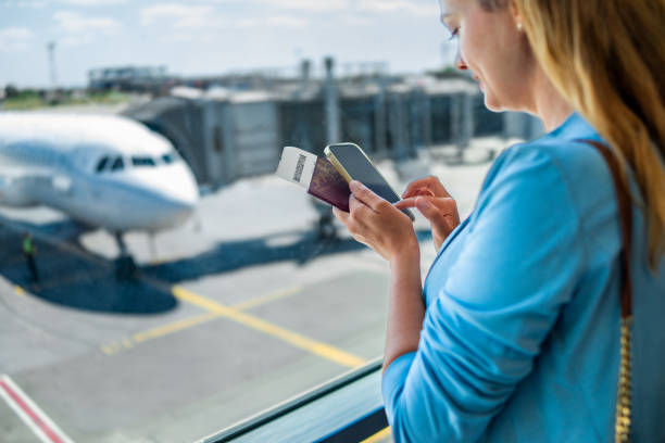 istock Young woman using her phone at the airport 1415709634