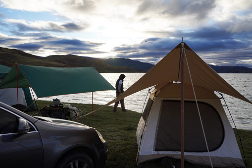 Camping picnic tent campground in outdoor hiking forest. Camper while campsite in nature background at summer trip camp. Adventure Travel Vacation concept