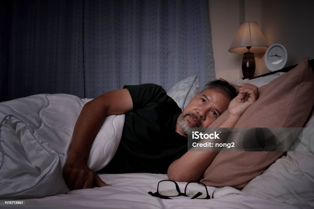 depressed old man and stressed lying in bed from insomnia Insomnia Stock Photo