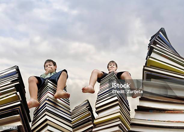 Children Sitting On Books Tower Stock Photo - Download Image Now - Book, Stack, Boys