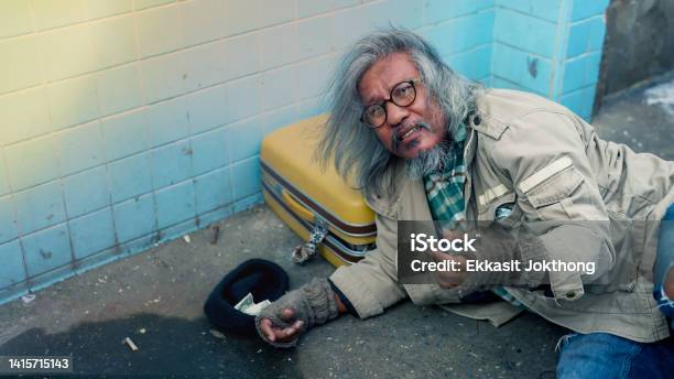 A Homeless Man Notoriously Busy Seeks Help From Passersby Starving With No Food To Eat From Homelessness And Joblessness The Poor Man Had No Home To Live Streets Stock Photo - Download Image Now