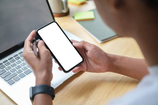 istock Close up view of man holding mock up smart phone with blank screen. 1415724009