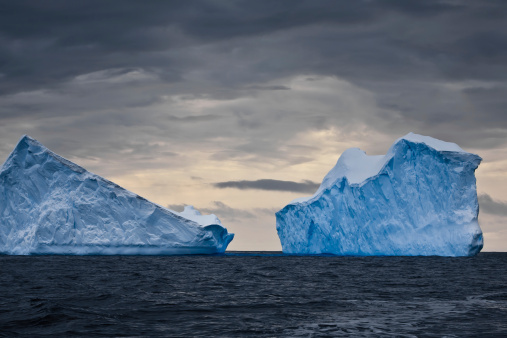Huge icebergs in Antarctica, dark sky