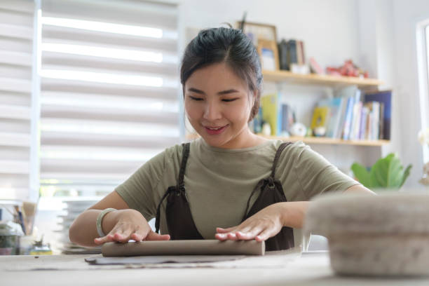 istock Young female potter creating handicraft crockery in her workshop. Creative activities, pottery, workshop, ceramics art concept. 1415725538