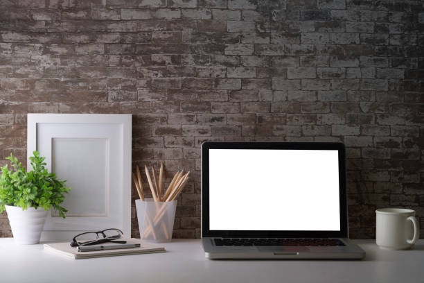 istock Laptop computer, picture frame, houseplant and stationery on white table. Modern workplace. 1415726036