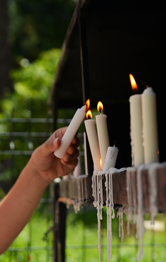 Woman lighting candles in a church garden