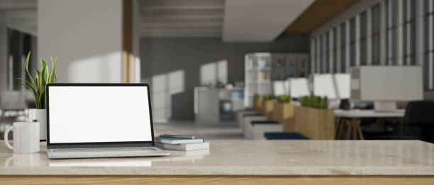 Workspace tabletop with laptop mockup and copy space over blurred office background stock photo