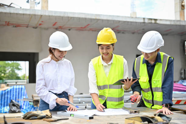 istock Asian female architect checking details on blueprint during meeting with an engineers 1415728485