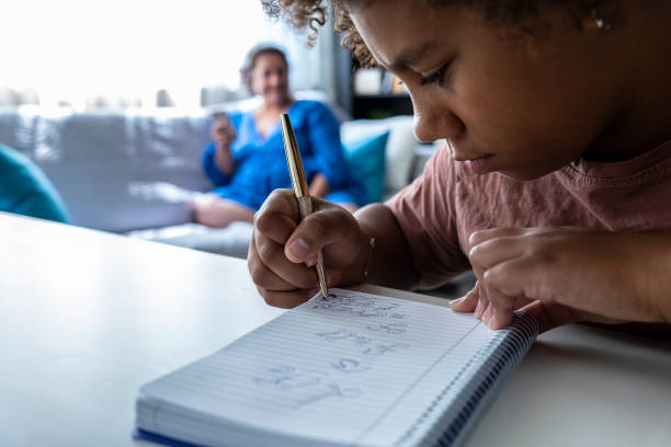 istock Hands in action. Black girl draws in her notebook at home. 1415730468