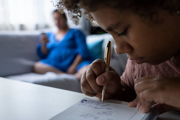 istock Hands in action. Black girl draws in her notebook at home. 1415730469