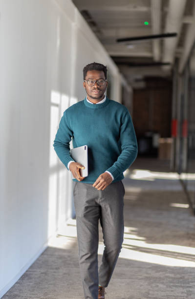 istock Young black businessman walking with his tablet 1415732094