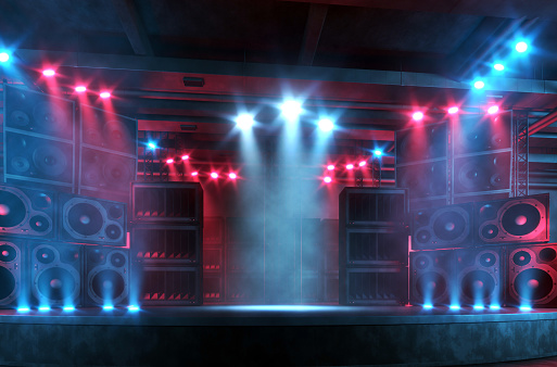 Music concert backdrop: front view of an empty stage illuminated by bright red and blue spotlights, surrounded by a large and loud sound system with plenty of loudspeakers. Punk and rock music background with copy space for adding items and characters. Digitally generated concert backdrop.