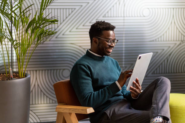 istock Smiling young black man having a video call on his tablet 1415732782