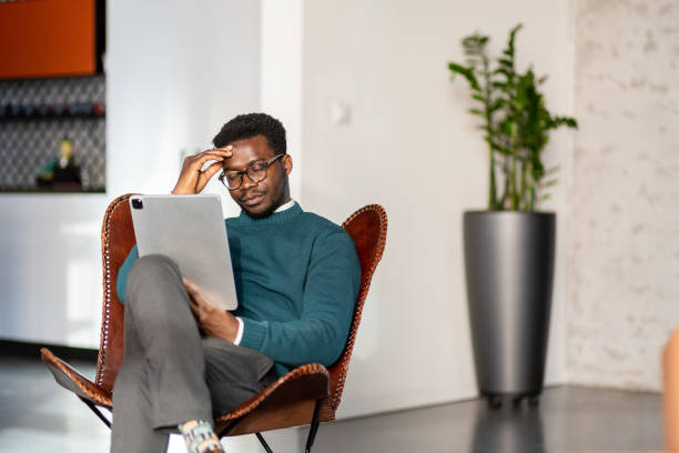 istock Young black businessman worried about data on his tablet 1415732835