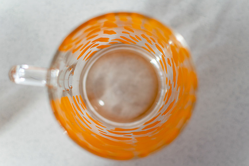 A bird’s eye view of a coffee mug with orange abstract design