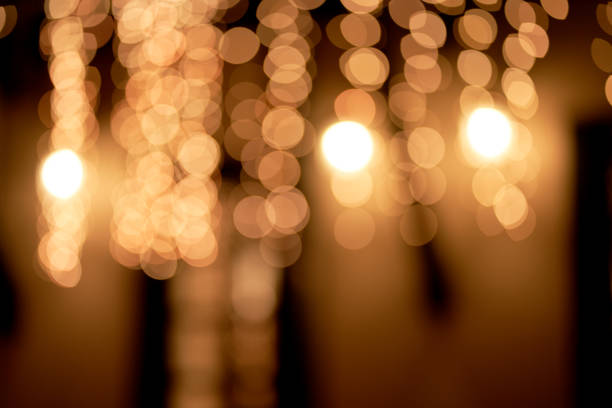 istock Abstract glowing bokeh lights highlighted on a black background. Festive golden glowing background with yellow lights. Overlay bokeh for your design. 1415734294