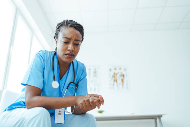 Young medical practitioner looking stressed out in a hospital Shot of a young medical practitioner looking stressed out in a hospital Tensed stock pictures, royalty-free photos & images