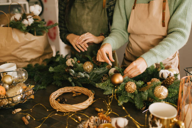 istock Two millennial women making Christmas wreath using pine branches and festive decorations. Small business 1415734746