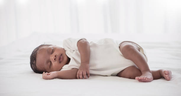 retrato del cuerpo del bebé recién nacido afroamericano durmiendo en la cama. primer plano del bebé recién nacido. me encanta la atención médica familiar y la guardería de partes del cuerpo médico juntos feliz concepto del día de la madre - sleeping baby fotografías e imágenes de stock