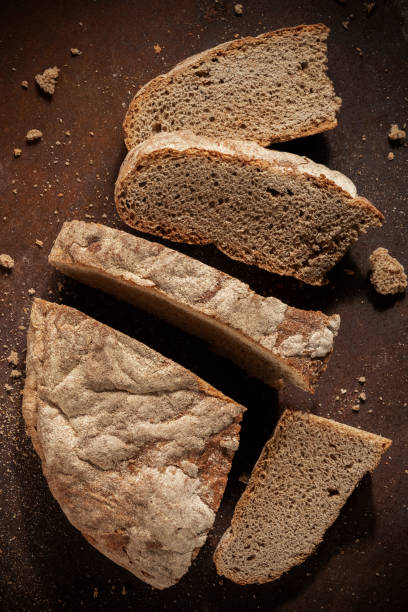 istock Low key food photography. Black rustic bread on dark background 1415736630