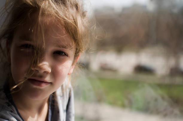 A thoughtful girl looks out the window.