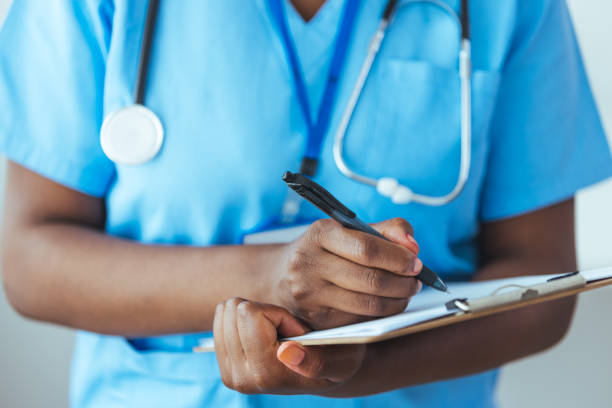 istock Unrecognizable nurse checking a patients medical chart 1415737501