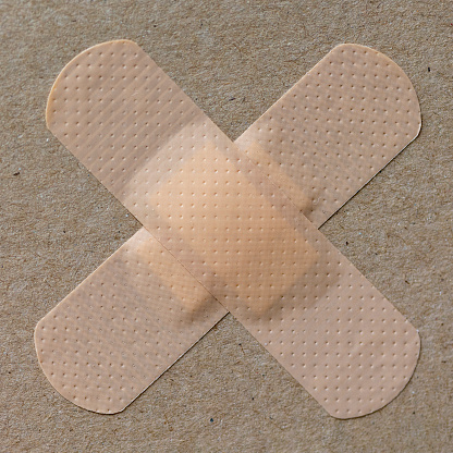 Medical patch glued to cardboard in the shape of a cross