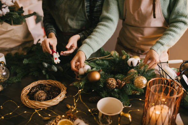 istock Two millennial women making Christmas wreath using pine branches and festive decorations. Small business 1415741790