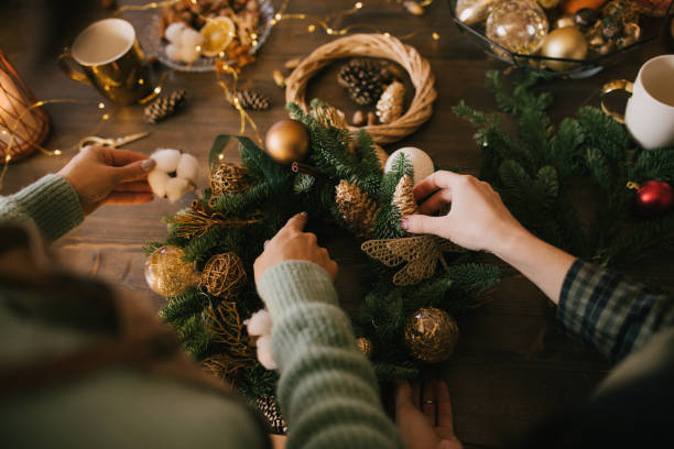 istock Two millennial women making Christmas wreath using pine branches and festive decorations. Small business 1415741805