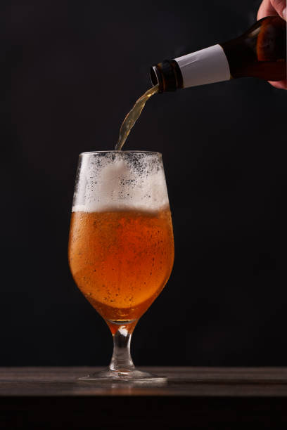 istock Pouring beer into glass at the bar counter. 1415744577