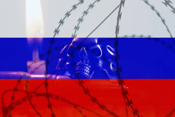 Photo of The flag of Russia against the background of barbed wire and a skull vozla candles. War in Ukraine. Stop war and peace in Ukraine, Russia against the law