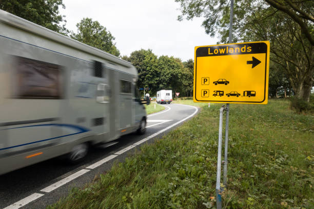 Yellow road signs to Lowlands Festival Two campers pass a yellow road sign near Walibi, Flevoland, indicating the direction to the festival site of A Campingflight to Lowlands Paradise, a three-day festival featuring music, theatre, film, comedy, literature, street theatre, science and visual arts in Biddinghuizen. biddinghuizen stock pictures, royalty-free photos & images