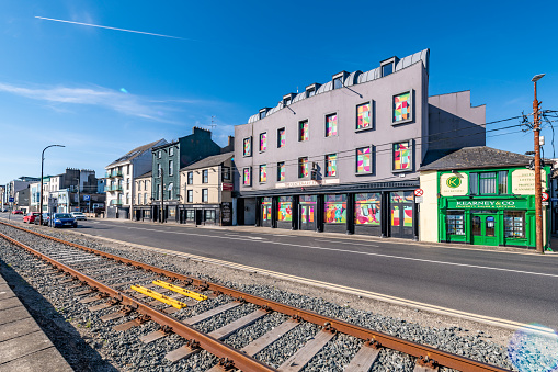 Wexford, Ireland. 7 August 2022. Tram lines run along Wexford seafront with shops and town behind