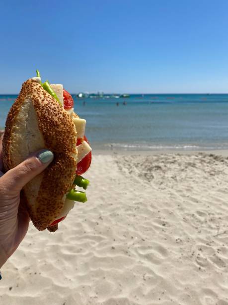 istock Woman holding a sandwich on the beach 1415751413