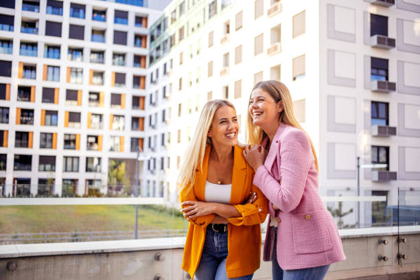 Two blonde business women having fun conversation wearing casual corporate clothing