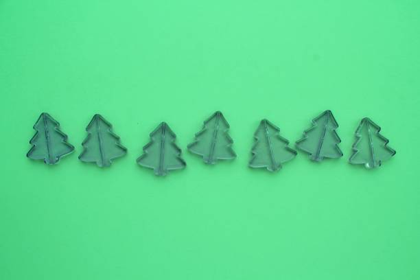 istock Christmas composition from little plastic pine trees on green background with copy space for text 1415752608