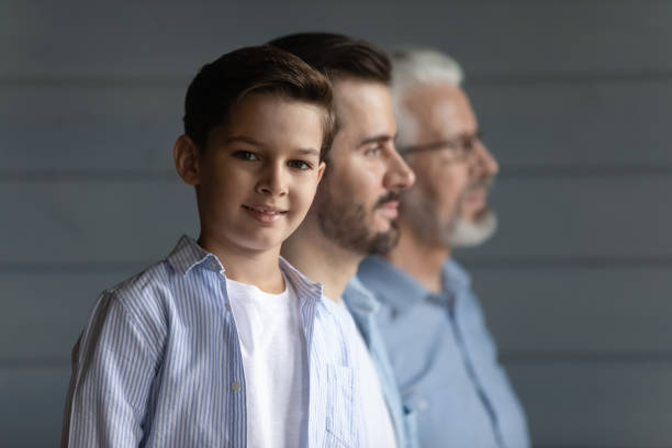 istock Three diverse men grandfather father little boy stand in row 1415754651