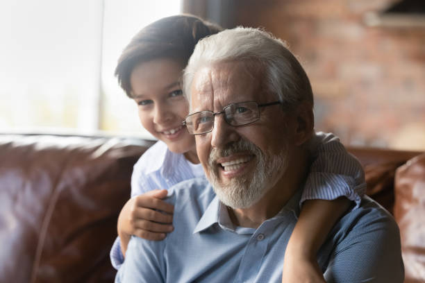 istock Overjoyed little grandkid cuddle from back smiling mature grandfather 1415754665