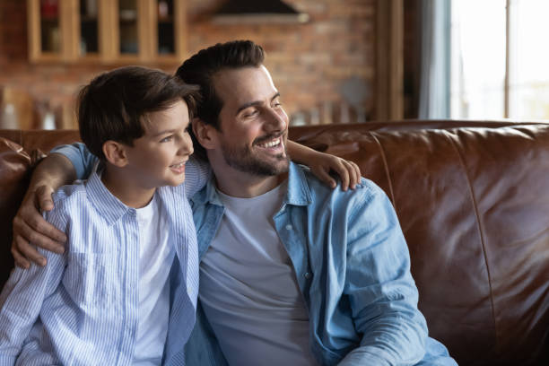 istock Smiling young man father hugging beloved child son dreaming together 1415754668