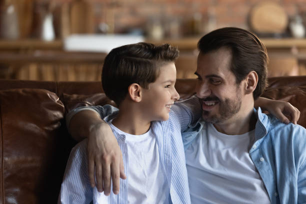 istock Affectionate single dad enjoy chatting with little son at home 1415754672