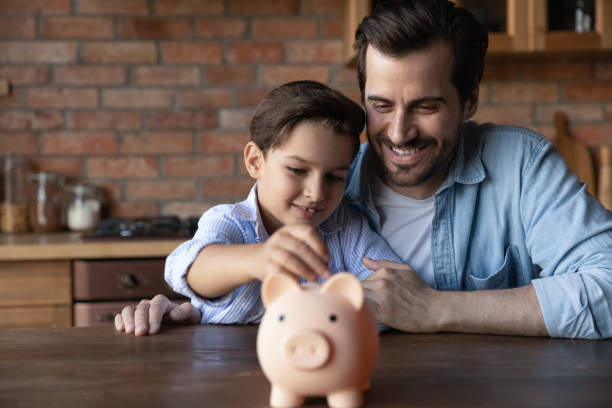 Smiling father support preteen son in wish to save money ABC of finance. Smiling father support junior school age son in wish to save pin money teach rational economy wise budget planning. Caring dad hug preteen child boy putting pocket change to piggybank financial literacy stock pictures, royalty-free photos & images