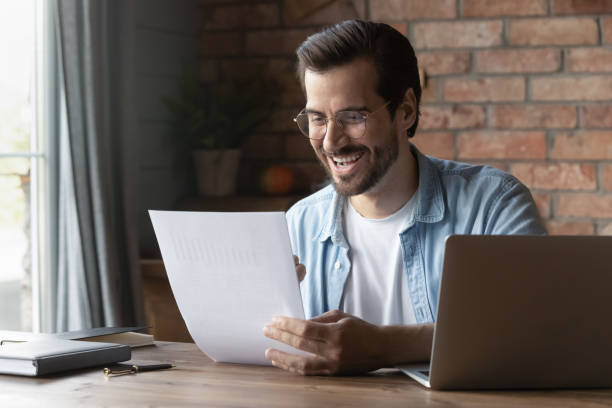 istock Excited male manager read paper document with data in graphs 1415755573