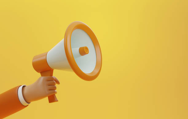 istock Hand holding a megaphone on a yellow background 1415755888