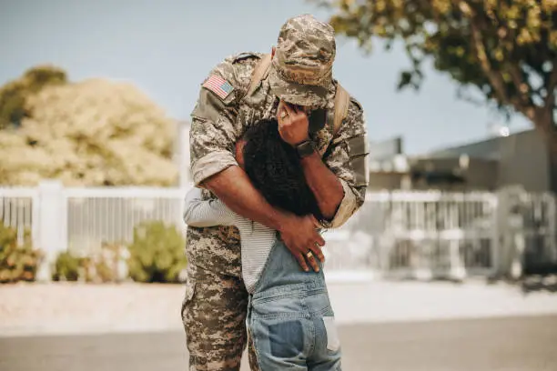 Tearful military parting. Emotional soldier saying his goodbye to his daughter before going to war. Patriotic serviceman embracing his child before leaving to go serve his country in the army.