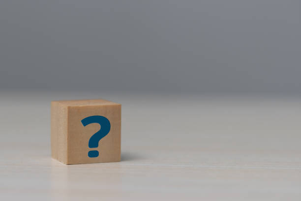 istock Wooden cube block shape with sign question mark symbol on table. 1415758002