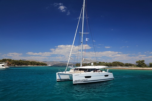 Fountaine-Pajot catamaran anchored in a bay on Adriatic Sea. Fountaine-Pajot is a French maritime construction company specializing in catamarans.