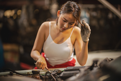 Portrait of woman repairing a car in auto repair shop - stock video