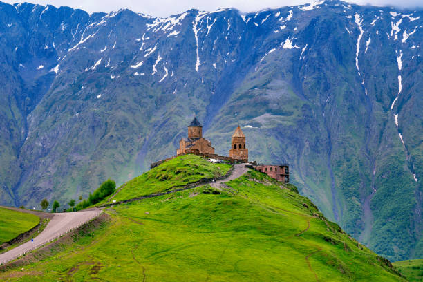 iglesia de la trinidad gergeti (tsminda sameba) en kazbegi, georgia. - mountain mountain peak environment caucasus fotografías e imágenes de stock