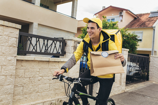 Bicycle delivery commuter with road bicycle delivering package to customer